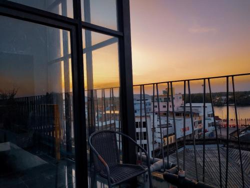 a balcony with a chair and a view of a harbor at The Harbour Front Hotel in Suratthani