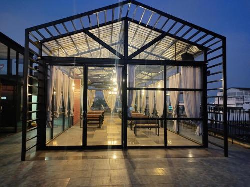 a large glass house with a table and chairs on a roof at The Harbour Front Hotel in Suratthani