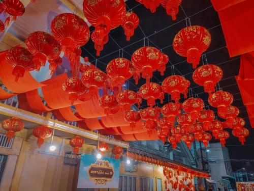 a bunch of red lanterns hanging from a ceiling at The Harbour Front Hotel in Suratthani