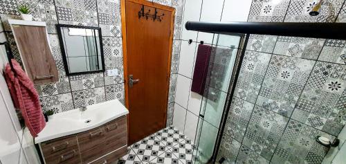 a bathroom with a sink and a glass shower at A CASA AMALELA in Gonçalves