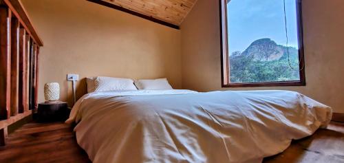 ein Schlafzimmer mit einem großen Bett und einem großen Fenster in der Unterkunft A CASA AMALELA in Gonçalves