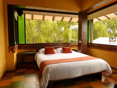sypialnia z łóżkiem i dużym oknem w obiekcie Bombon hotel spa w mieście Villa de Leyva