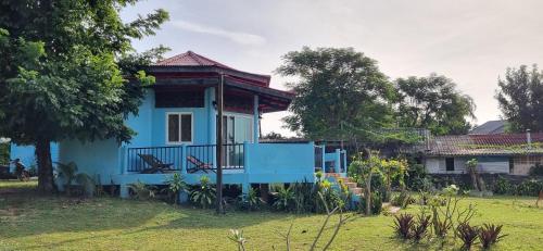 a blue house with a balcony in a yard at Miss You Beach Resort Koh Mak in Ko Mak
