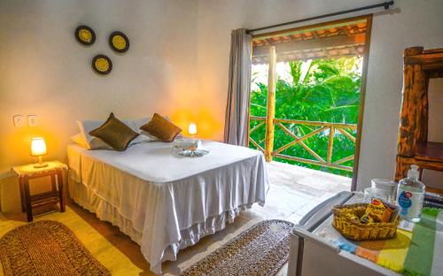 a bedroom with a bed and a large window at Paraiso da Barra in Barra Grande