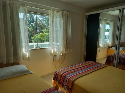 a bedroom with two beds and a window at Apto de 2 quartos vista pro mar de Itaúna in Saquarema