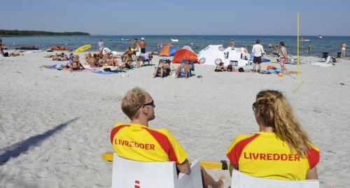 two people in life jackets standing on a beach at Hotel Balka Strand in Neksø