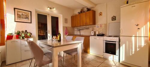 uma cozinha com uma mesa e um frigorífico branco em Apartment Close to the beach em Stari Grad