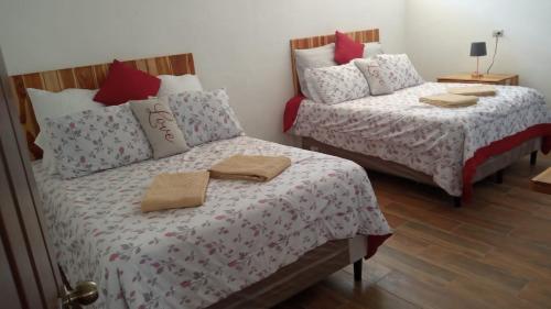 dos camas sentadas una al lado de la otra en una habitación en Apartamentos Mundo Maya en Flores