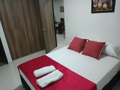 una camera da letto con un letto con cuscini rossi e bianchi di Apartamento turístico amoblado Barbosa a Barbosa