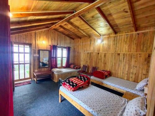 a room with two beds in a wooden cabin at Mowgli Town Homestay/Resort in Nainital