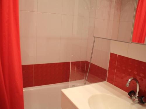 a bathroom with a sink and a red shower curtain at Studio Châtel, 1 pièce, 4 personnes - FR-1-200-362 in Châtel