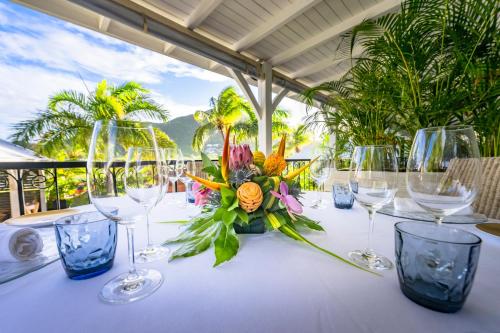 a table with wine glasses and flowers on it at La Villa Hibiscus, Saint Martin in Cul de Sac