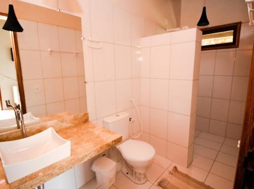 a white bathroom with a sink and a toilet at Paraiso da Barra in Barra Grande