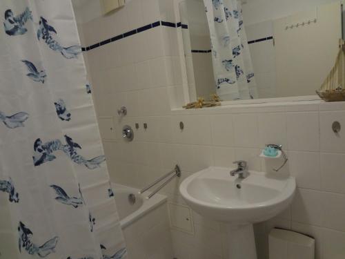a bathroom with a sink and a shower curtain at Bright Apartment in Boltenhagen near the Sea in Boltenhagen