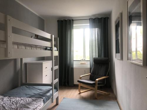 ボルテンハーゲンにあるBright Apartment in Boltenhagen near the Seaのベッドルーム(二段ベッド1組、椅子付)