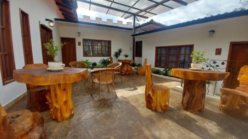 a room with wooden tables and chairs and trees at El Castillo de Nallig in Gualaceo