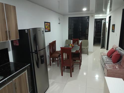 cocina y comedor con nevera y mesa en Apartamento turístico amoblado Barbosa en Barbosa