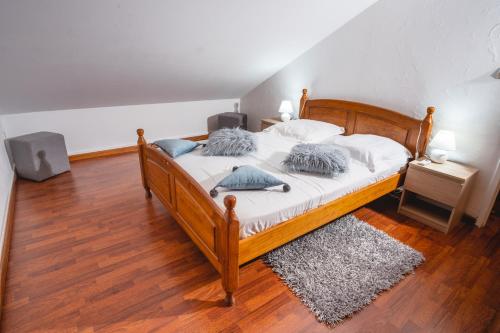 una camera da letto con letto in legno, lenzuola bianche e cuscini blu di Le Coin d'Azur a Petite-Île