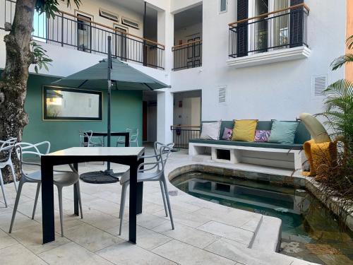a patio with a table and chairs next to a pool at Cosy Guest House Sous le Badamier in Grand Baie