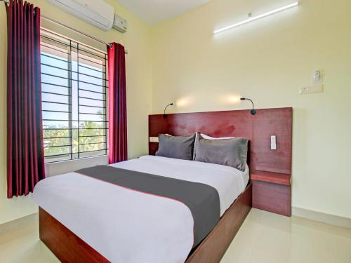 特里凡得琅的住宿－BLUEWAY RESIDENCY BUSINESS BOUTIQUE HOTEL，一间卧室设有一张大床和一个窗户。