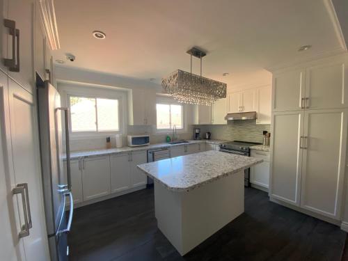 a kitchen with white cabinets and a large island at Yonge and Finch Subway !P Cozy & Quiet Private Bdr with Private Bathroom in Toronto
