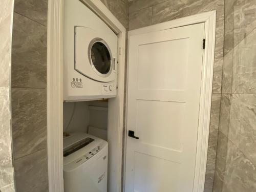 a laundry room with a microwave and a washer and dryer at Yonge and Finch Subway !P Cozy & Quiet Private Bdr with Private Bathroom in Toronto