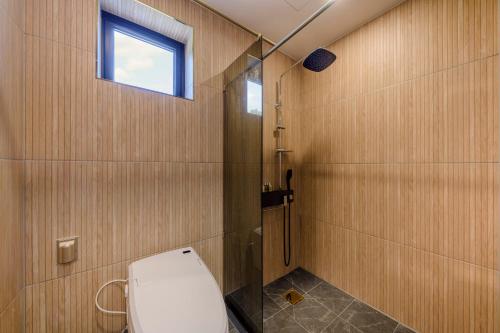 a bathroom with a toilet and a window at Hotel HaruSida in Seogwipo