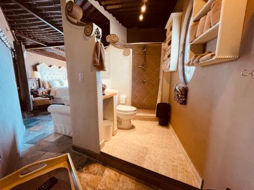 La petite salle de bains est pourvue d'une douche et de toilettes. dans l'établissement Casa Grande Luxury Boutique Hotel, à San Miguel de Allende