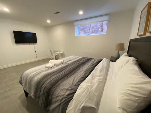a bedroom with a large bed with a tv on the wall at Yorkmills and Bayview !B Spacious and Stylish Private Bdr with Shared Bathroom in Toronto