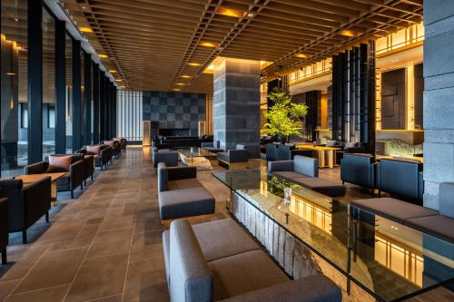 a lobby of a hotel with couches and tables at Pearl Star Hotel ATAMI in Atami