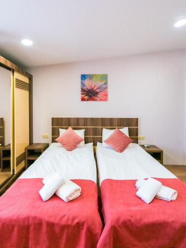 two beds in a room with red and white sheets at Hotel Classic Suites in Tbilisi City
