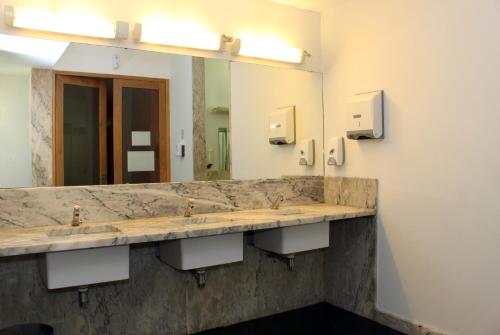 La salle de bains est pourvue de 2 lavabos et d'un grand miroir. dans l'établissement HI Viana do Castelo - Pousada de Juventude, à Viana do Castelo