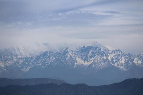 a view of a mountain range with snow covered mountains at Meraki - Entire 2BHK Villa With Himalayan Views in Rānīkhet