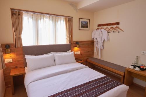 a bedroom with a large bed and a window at The Willows Hotel, Bhutan in Thimphu