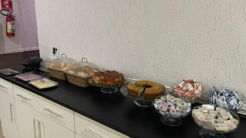 a counter with several baskets of food on it at Hotel Tenda Brigadeiro SP in Sao Paulo