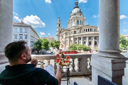 a man standing on a balcony looking at a building at TOP Luxury Suites in Budapest
