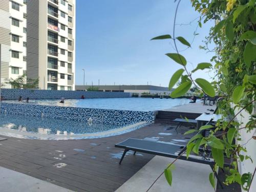 a swimming pool with a table next to a building at Cikgukay Desaru Homestay Apartment With Pool View WiFi & Netflix in Bandar Penawar