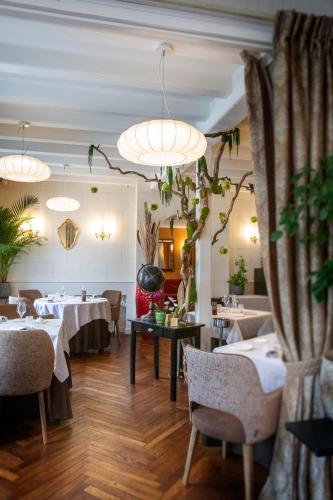 un restaurant avec des tables, des chaises et des plantes en pot dans l'établissement Logis Hôtel La Brèche - Restaurant Berthelot, à Amboise