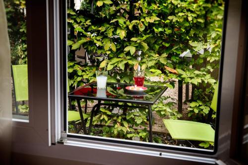 a table with two glasses and a drink on a window at Logis Hôtel Restaurant La Breche in Amboise