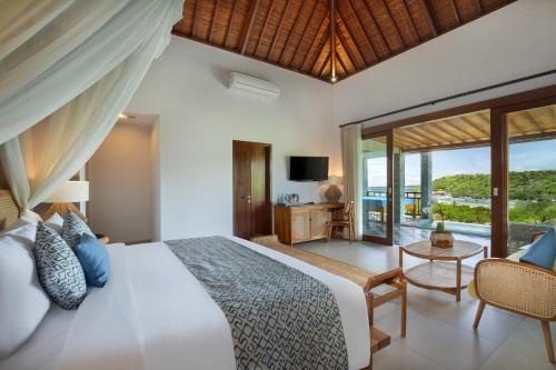 a bedroom with a bed and a view of the ocean at The Acala Shri Sedana in Nusa Lembongan