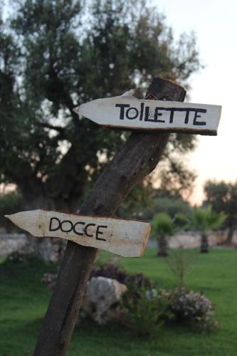 a wooden sign that says violence and dodge at Masseria Valente in Ostuni
