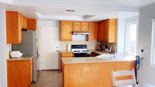 ランチョ・クカモンガにあるBrand New Single House sharing 2 Bedroomsのキッチン(木製キャビネット、白い冷蔵庫付)