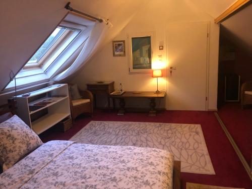 1 dormitorio con cama, escritorio y ventana en Les 3 Clés, en Dossenheim-Kochersberg