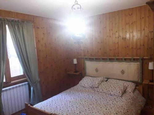 ein Schlafzimmer mit einem Bett und einer Lampe darüber in der Unterkunft Appartamento piano terra in centro paese. in Carona