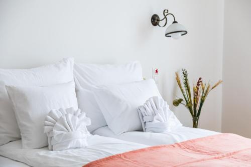 Una cama blanca con almohadas blancas encima. en Captain Buda Apartment, en Budapest