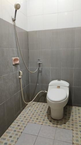 La salle de bains est pourvue d'une douche et de toilettes. dans l'établissement Hotel Artha, à Tjakranegara
