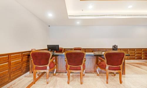 a meeting room with three chairs and a desk at Treebo Tryst Vahada in Alleppey
