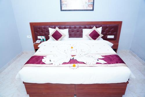 a bedroom with a large bed with white sheets at ExpoMart Inn in Greater Noida