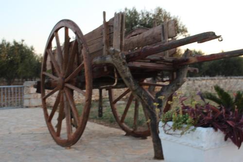 a wooden cart sitting on top of a sidewalk at Masseria Valente in Ostuni