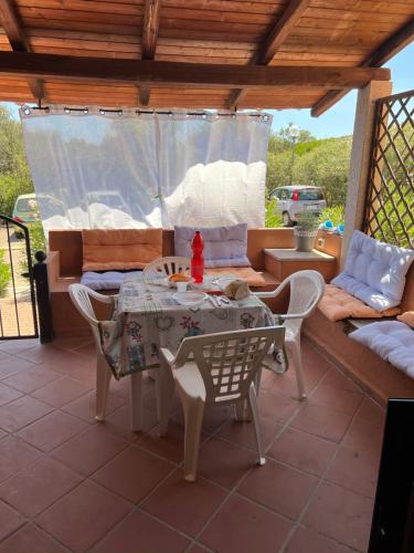 un patio con mesa, sillas y sofá en CASA MONELLA mono locale vista mare, en Marinella